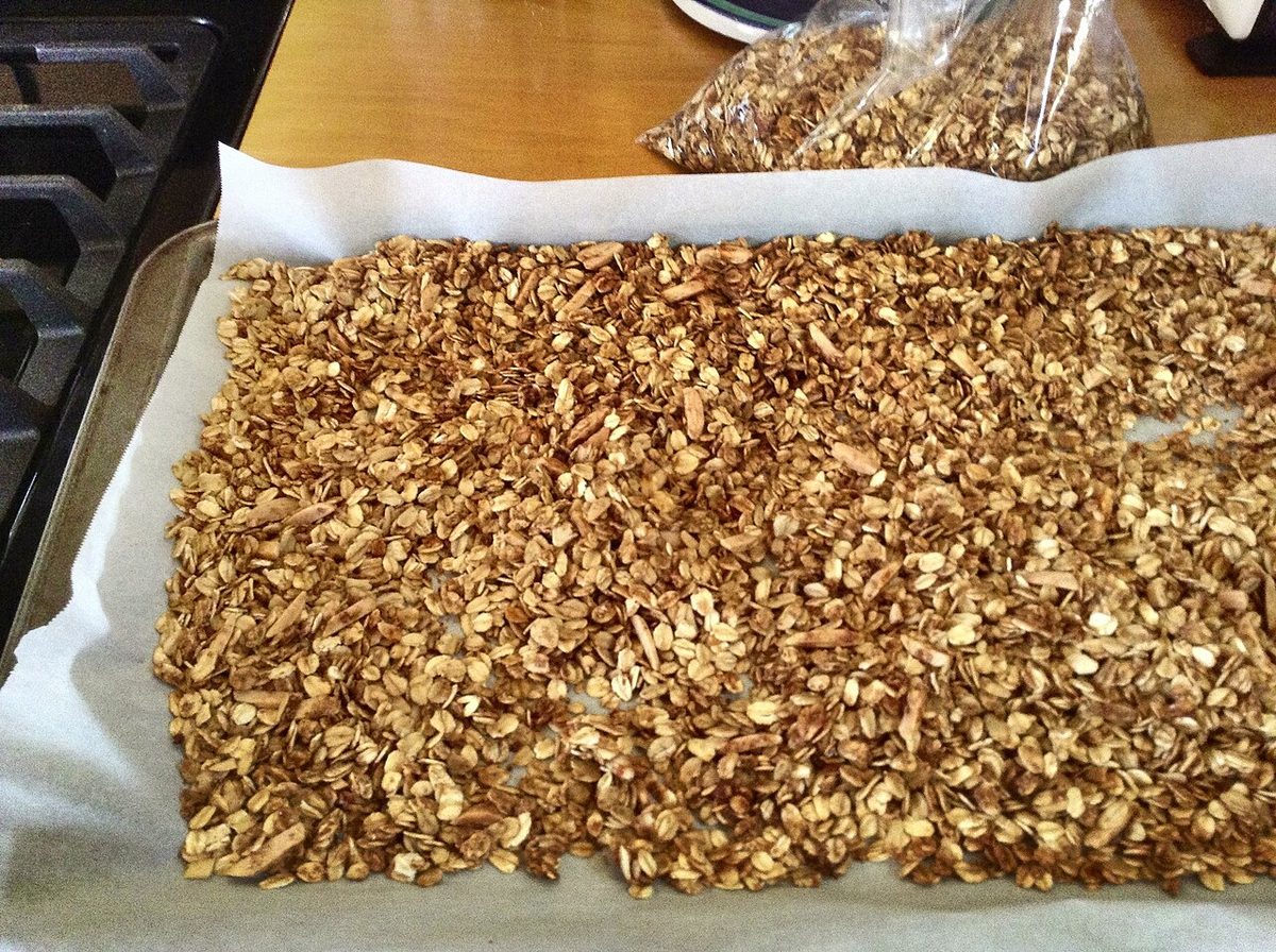Upieczona domowa granola rozłożona na blasze wyłożonej papierem do pieczenia